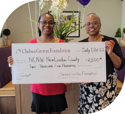 Two smiling people hold an oversized Chelsea Groton Foundation check for $2500