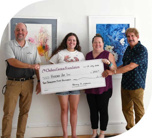 Four smiling people holding an oversized Chelsea Groton Foundation check for $2,500