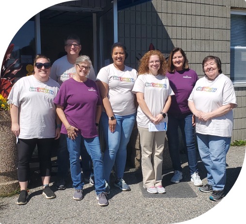 A cheerful group of volunteers from Chelsea Groton, a mutual bank,  wearing their ONE Chelsea shirts