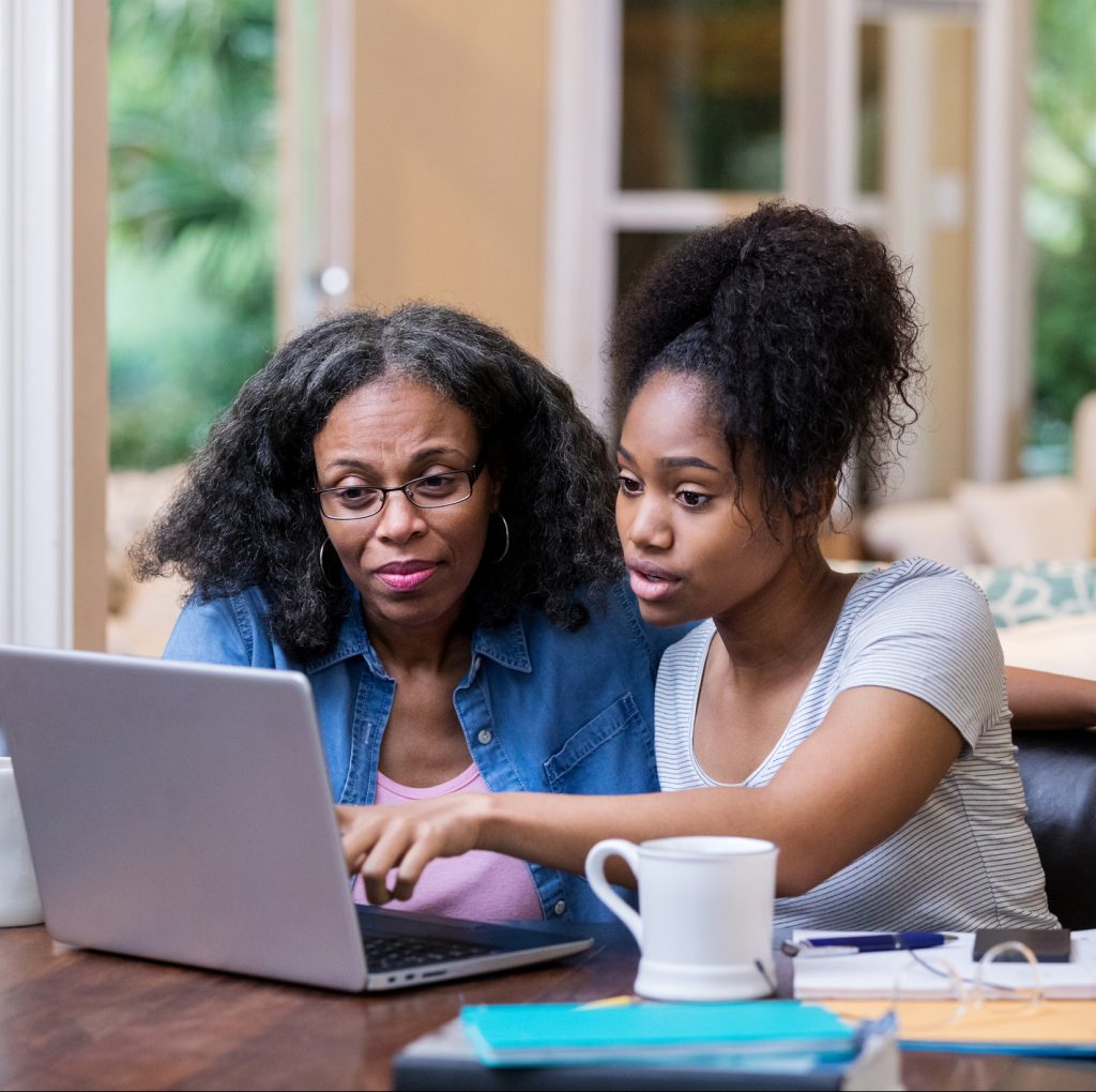 Young woman and her mother taking financial education classes online with laptop