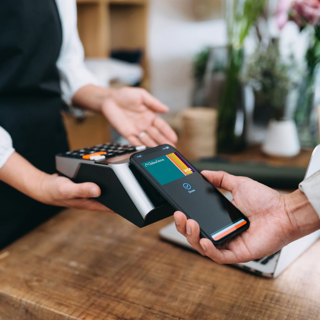 A business customer making a purchase with their Chelsea Groton Debit card on their mobile phone.