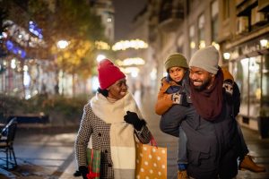 Mother, father and their son spending time together, walking on the street, shopping for Christmas present.