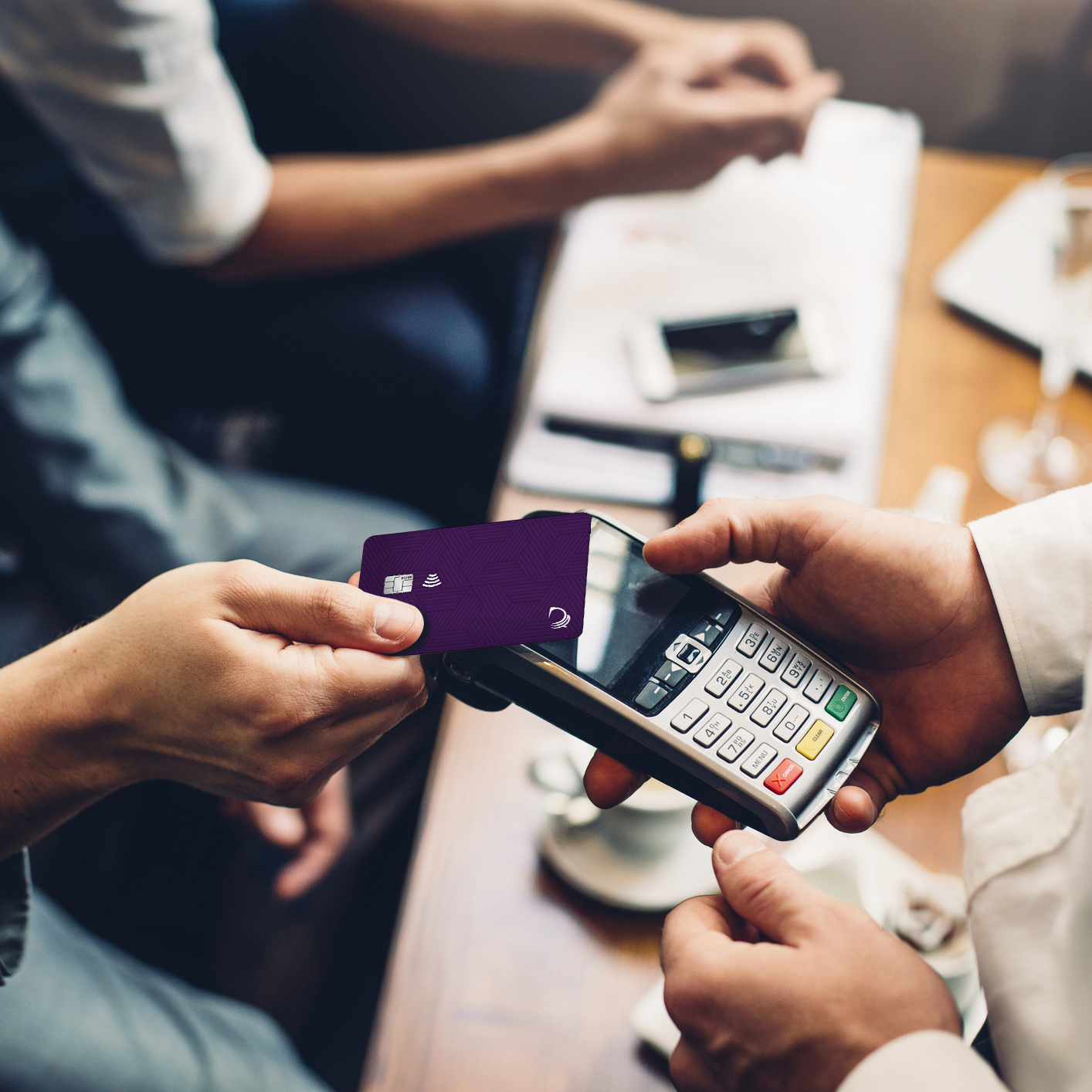 Close up of a card payment being made between a man and a waiter in a cafe.